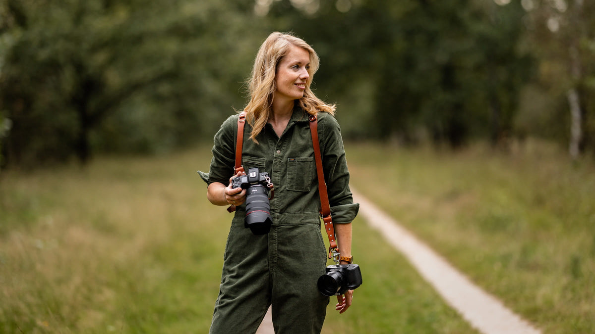 Fotograaf met twee camera's aan een leren cameraharnas tijdens een fotoshoot
